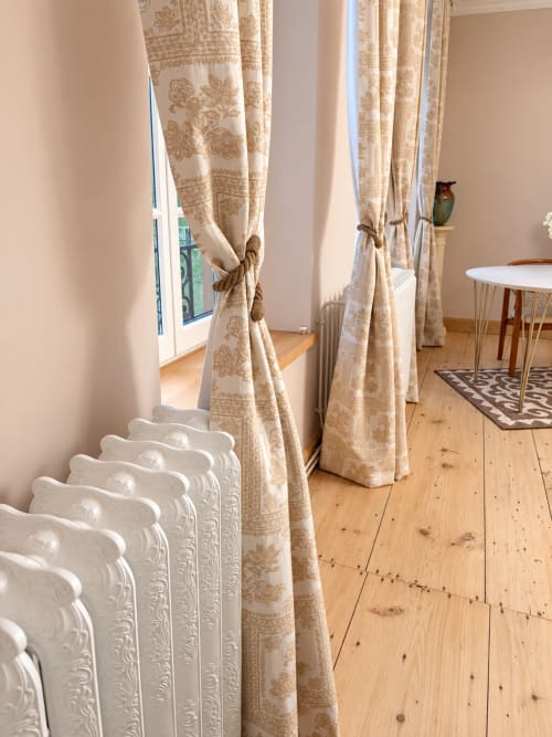 Élégante chambre Nordique à la Maison Crone avec rideaux à fleurs beiges, radiateur blanc orné, parquets et vues sur la ville