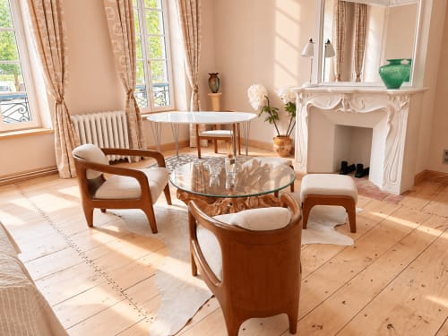 Élégant séjour à Maison Crone avec mobilier en bois, table basse en verre, cheminée et vue sur la ville par les grandes fenêtres