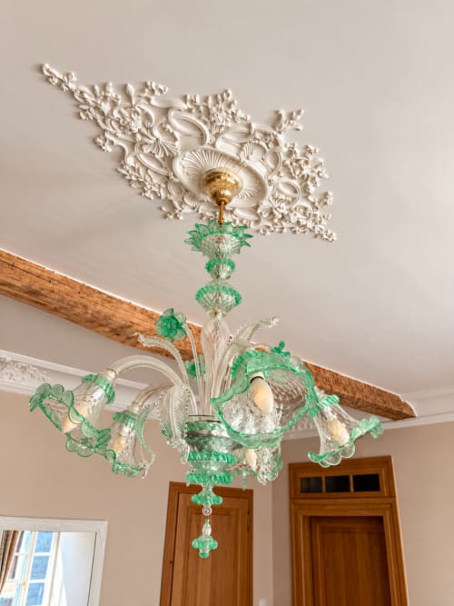 Élégant lustre en cristal vert sous une rosace ornementale dans la Chambre Nordique de Maison Crone