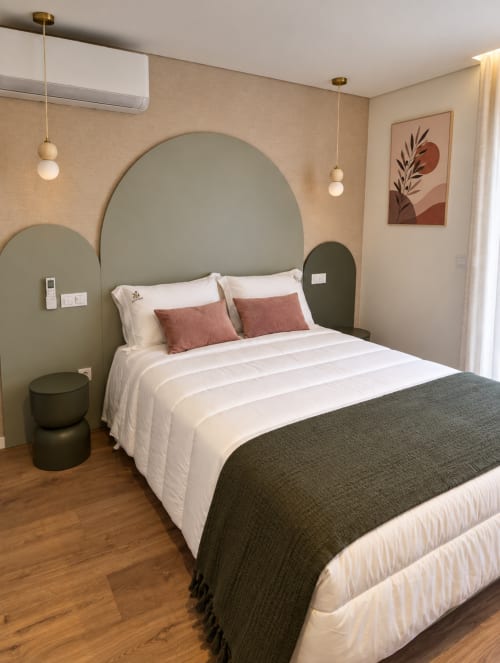 Quarto moderno na House Park em Esposende com cabeceira em verde sálvia, roupa de cama branca, luminárias pendentes e design minimalista