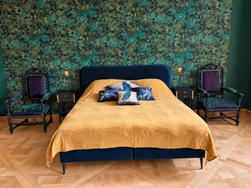 Chambre Émeraude de la Maison Crone avec papier peint floral turquoise, literie dorée et mobilier en bois foncé
