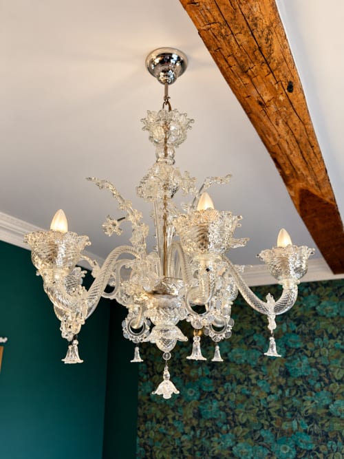 Lustre en cristal ouvragé dans la Chambre Émeraude de la Maison Crone à Castillon-en-Couserans, avec poutre apparente et émeraude