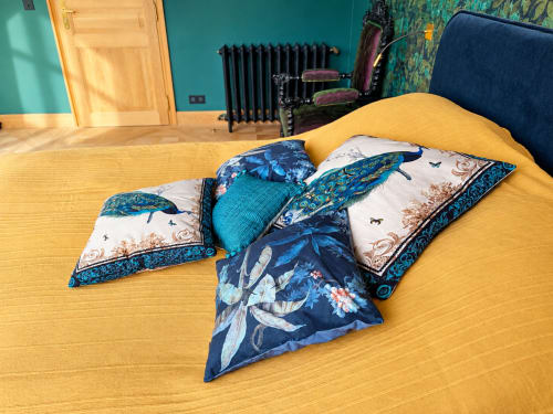 Coussins décoratifs disposés sur la literie jaune de la Chambre Émeraude à la Maison Crone, un bed and breakfast français