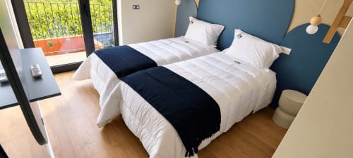 Quarto duplo na House Park em Esposende com vista para a montanha, roupa de cama branca, cabeceira azul e acesso à varanda