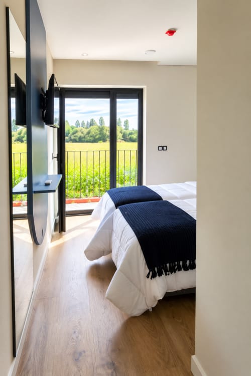 Quarto moderno com duas camas de solteiro na House Park B&B, Esposende, com vista para as montanhas da varanda privada com vistas para a vegetação