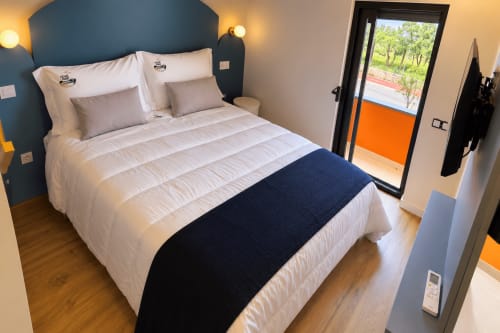 Quarto moderno com vista para o rio na House Park B&B em Esposende, Portugal, com roupa de cama branca e cabeceira azul
