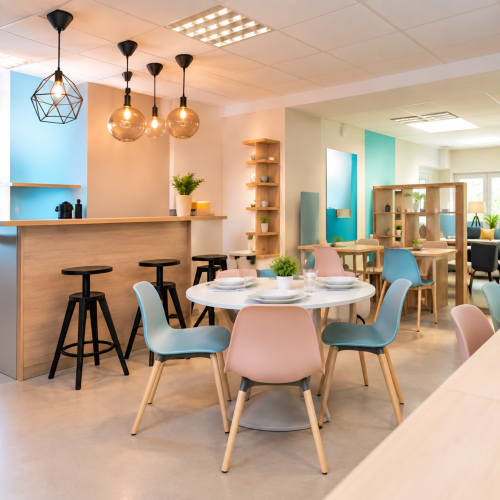 Espace de salle à manger contemporain à Un Air De Famille B&B à Vittel avec chaises pastel, table ronde blanche et luminaires suspendus
