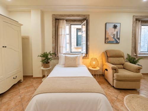 Estudio amueblado en Amodiño, Baiona con cama, sillón, suelos de madera y vistas a la ciudad