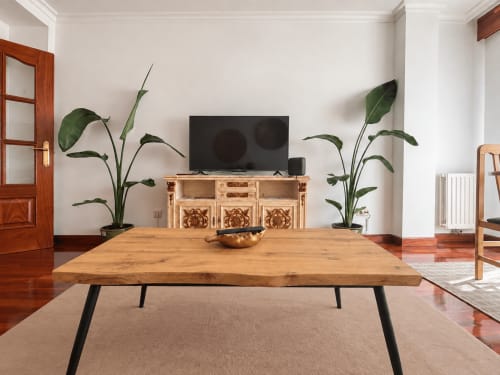 Sala moderna del apartamento Holibai en Baiona con mesa de comedor de madera, TV, plantas decorativas y muebles elegantes