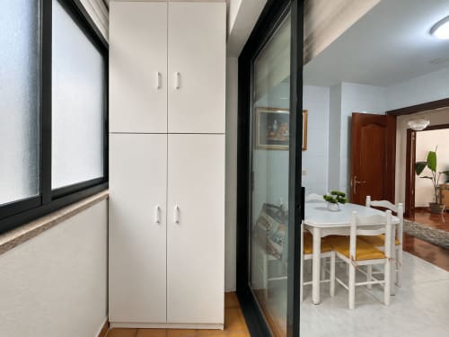 Cocina y comedor moderno en Baiona con muebles blancos, mesa pequeña y sillas