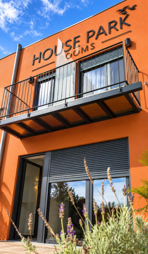 Exterior do House Park Rooms em Esposende, Portugal - edifício moderno laranja com varanda e jardim de lavanda