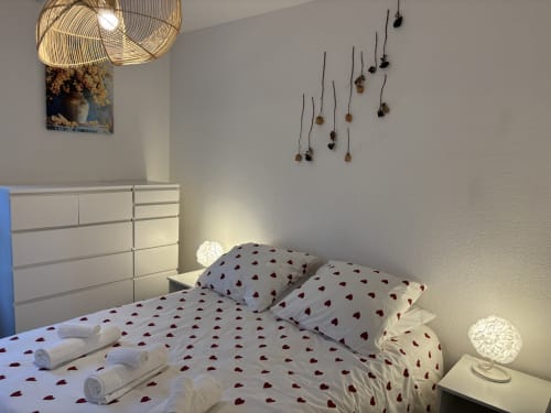 Chambre douillette du Mas Des Cigales De Lambesc à Aix-en-Provence avec literie à motifs de cœurs et éclairage chaleureux