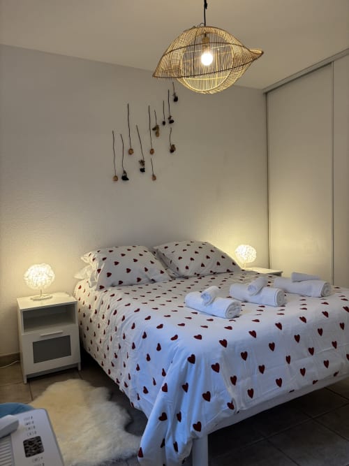 Chambre cosy au Mas Des Cigales De Lambesc, Aix-en-Provence, avec literie à motifs cœurs et éclairage suspendu