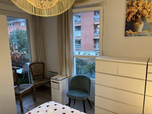 Chambre moderne à Mas Des Cigales De Lambesc à Aix-en-Provence avec vue sur la ville, fauteuil vert et mobilier élégant