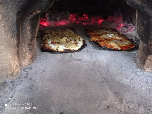 Deux pizzas fraîchement cuites dans le four à bois de La Ferme Buissonnière, Biol France