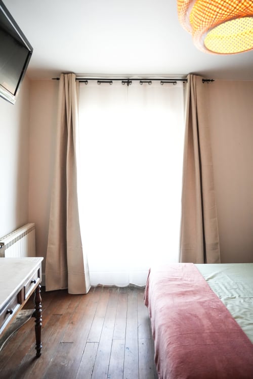 Habitación luminosa en Le Saint Laurans con cortinas beige, piso de madera y vista al jardín en Aurignac
