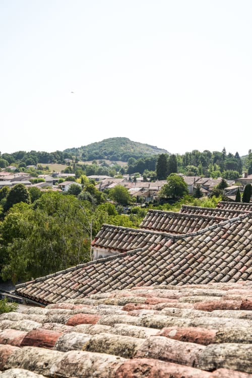 Tejados del pueblo de Aurignac y paisaje rural verde cerca del hotel Le Saint Laurans
