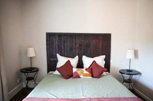 Acogedora habitación del hotel Le Saint Laurans en Aurignac con cabecero de madera oscura, almohadas blancas y cojines burdeos