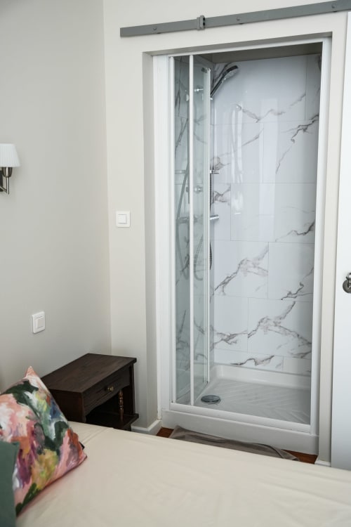 Modern shower enclosure with marble tiles in Chambre B at Le Saint Laurans hotel, Aurignac