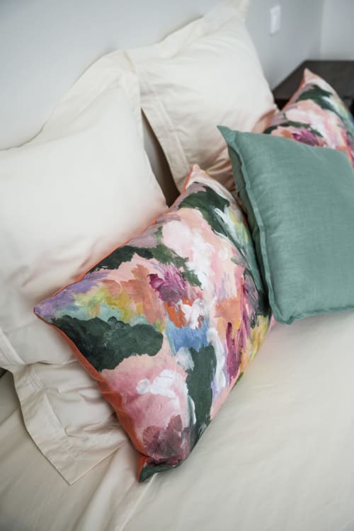 Colorful floral pillows on white bedding in a hotel room at Le Saint Laurans, Aurignac