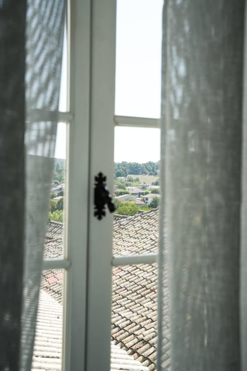 View from Le Saint Laurans hotel window in Aurignac, showing terracotta rooftiles and countryside landscape