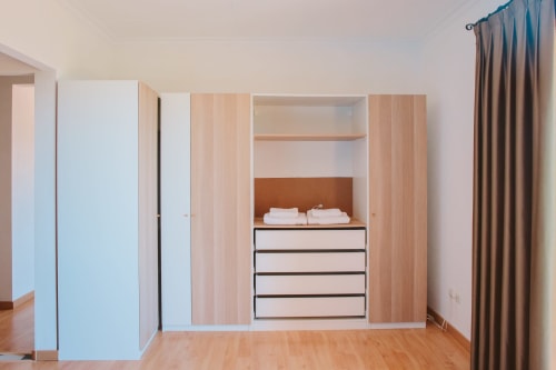 Spacious built-in wardrobe with drawers and shelving in Balcó del Priorat Family Room, Tarragona hotel.