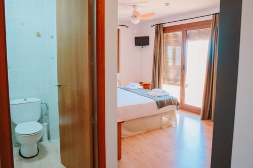 Family Room at Balcó del Priorat hotel in Tarragona with bed, bathroom, TV, and mountain views