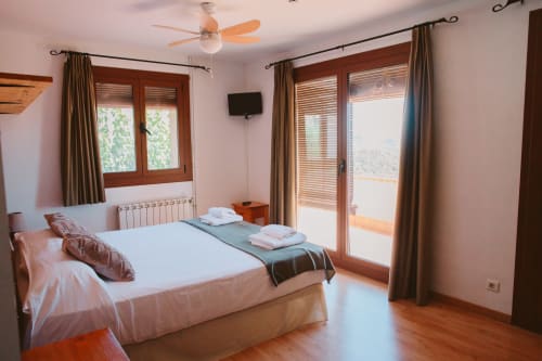 Bright family room at Balcó del Priorat in Tarragona with double bed, mountain views, TV, and terrace access