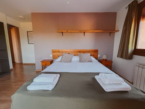Spacious Family Room at Balcó del Priorat, Tarragona with wooden bed, twin bunks, and mountain view