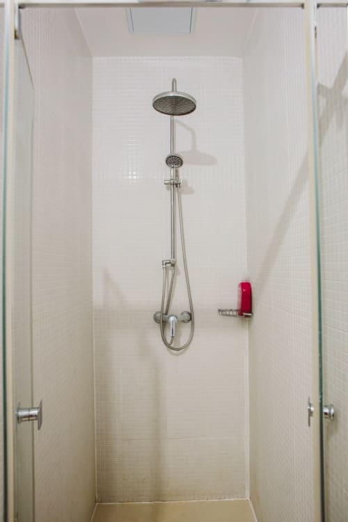 Modern shower enclosure with rainfall showerhead and hand shower in Balcó del Priorat hotel bathroom, Tarragona