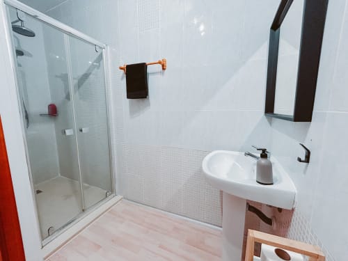 Modern bathroom in Balcó del Priorat Family Room, Tarragona, with shower enclosure, pedestal sink, and copper towel rail