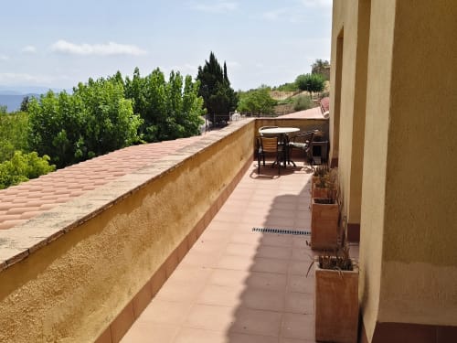 Terrace at Balcó del Priorat hotel in Tarragona with mountain views, seating area, and cypress trees