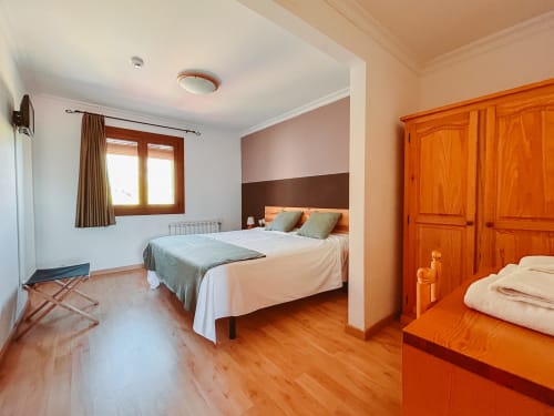 Spacious double bedroom at Balcó del Priorat hotel in Tarragona with wooden wardrobes, mountain views, and modern amenities