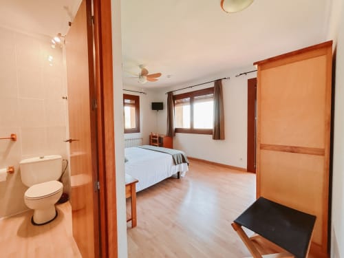Spacious corner room at Balcó del Priorat hotel in Tarragona with bed, ensuite bathroom, and mountain views