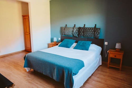 Moderna habitación doble en el hotel Balcó del Priorat en Tarragona con detalles turquesas, muebles de madera y vistas a la montaña