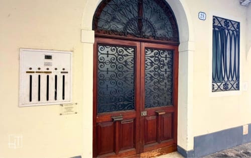 Elegant red wooden entrance door with ornate ironwork at Hometoday apartment in Padova historic center