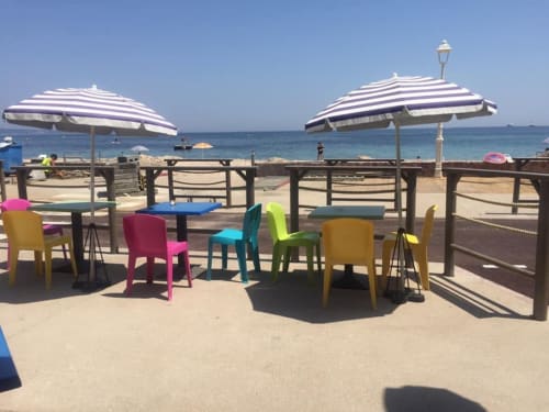 Espace détente balnéaire coloré avec parasols rayés donnant sur la Méditerranée à Cannes