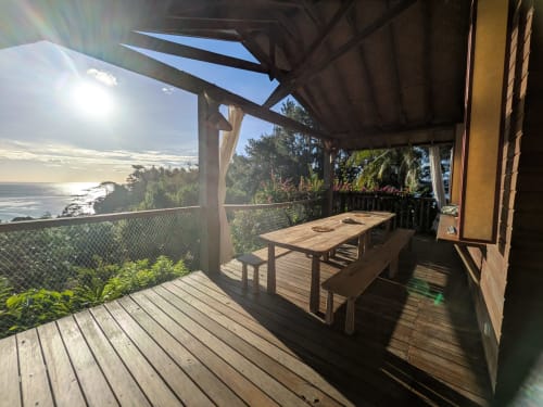 Terrasse avec vue océan au Fare Tihi Moana, table à manger, pergola ombragée et vue côtière à Tumaraa, Polynésie française