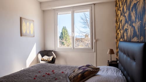 Chambre Tropicale na Maison de Barlest com vista para as montanhas, cama com cabeceira preta e decoração tropical