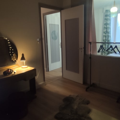Quarto moderno da Maison de Barlest com escrivaninha, luminária, portas espelhadas e vista para a cidade de Barlest, França