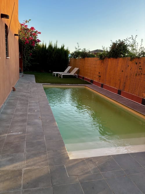 Backyard pool area at Skydivers Nest villa in Bollullos de la Mitación with turquoise water, terrace, loungers, and red brick