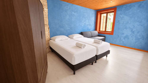 Modern twin bedroom with white beds, blue walls, wooden ceiling at Maison Agami in Rosières aux salines