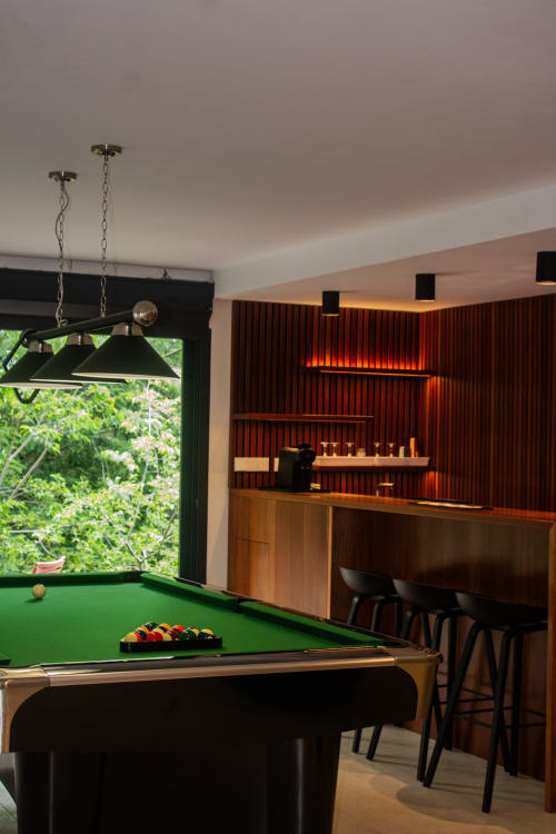 Salle de jeux moderne avec billard, bar accentué de rouge et vue sur le jardin à Villa Mahogany, Les Anses d'Arlet