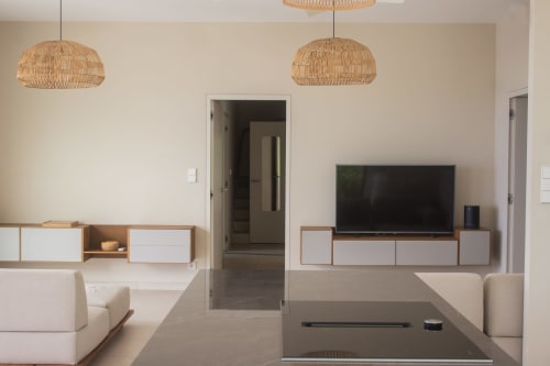 Salon moderne de l'hôtel INHÉRENCE au Lamentin avec suspensions tissées, mobilier blanc et TV murale