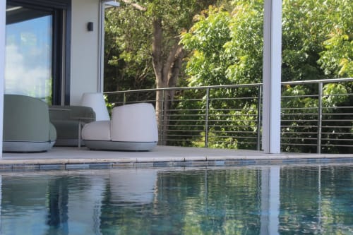 Coin détente contemporain à la piscine de l'hôtel INHÉRENCE au Lamentin, avec élégantes chaises blanches et vue luxuriante sur les tropiques