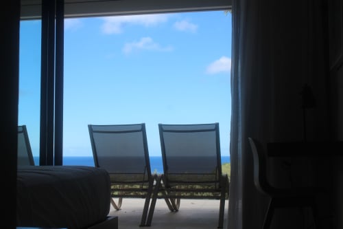 Vue océanique depuis le balcon de l'hôtel INHÉRENCE avec chaises longues donnant sur la mer des Caraïbes au Lamentin