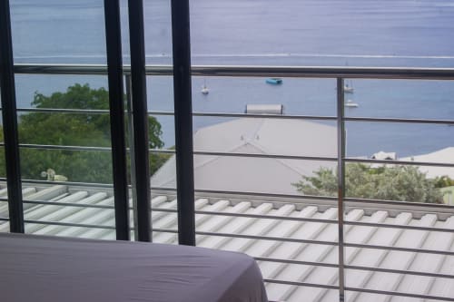 Vue depuis le balcon de l'hôtel INHÉRENCE au Lamentin, Martinique, surplombant la baie avec bateaux et végétation luxuriante