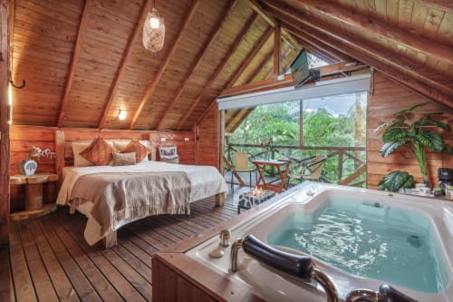 Lujosa habitación de glamping en madera con cama queen, bañera de hidromasaje y vistas a la selva desde el balcón en Sukha Glamping, Ríonegro