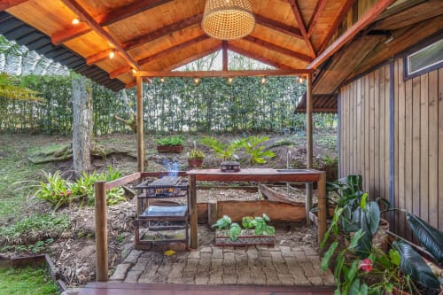 Patio techado de madera con cocina exterior y vistas al jardín en Sukha Glamping, Ríonegro, Colombia