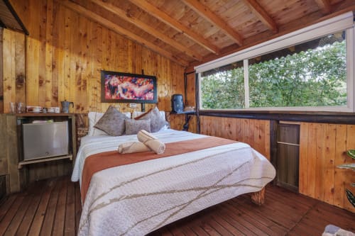 Habitación Eucalipto en Sukha Glamping, Ríonegro con interior de madera, cama, TV y vistas al jardín